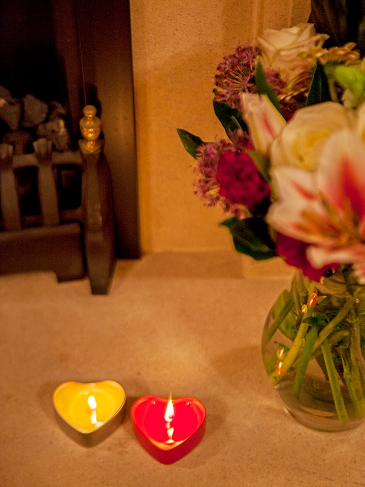 Two of our heart-shaped candles placed next to a vase of flowers