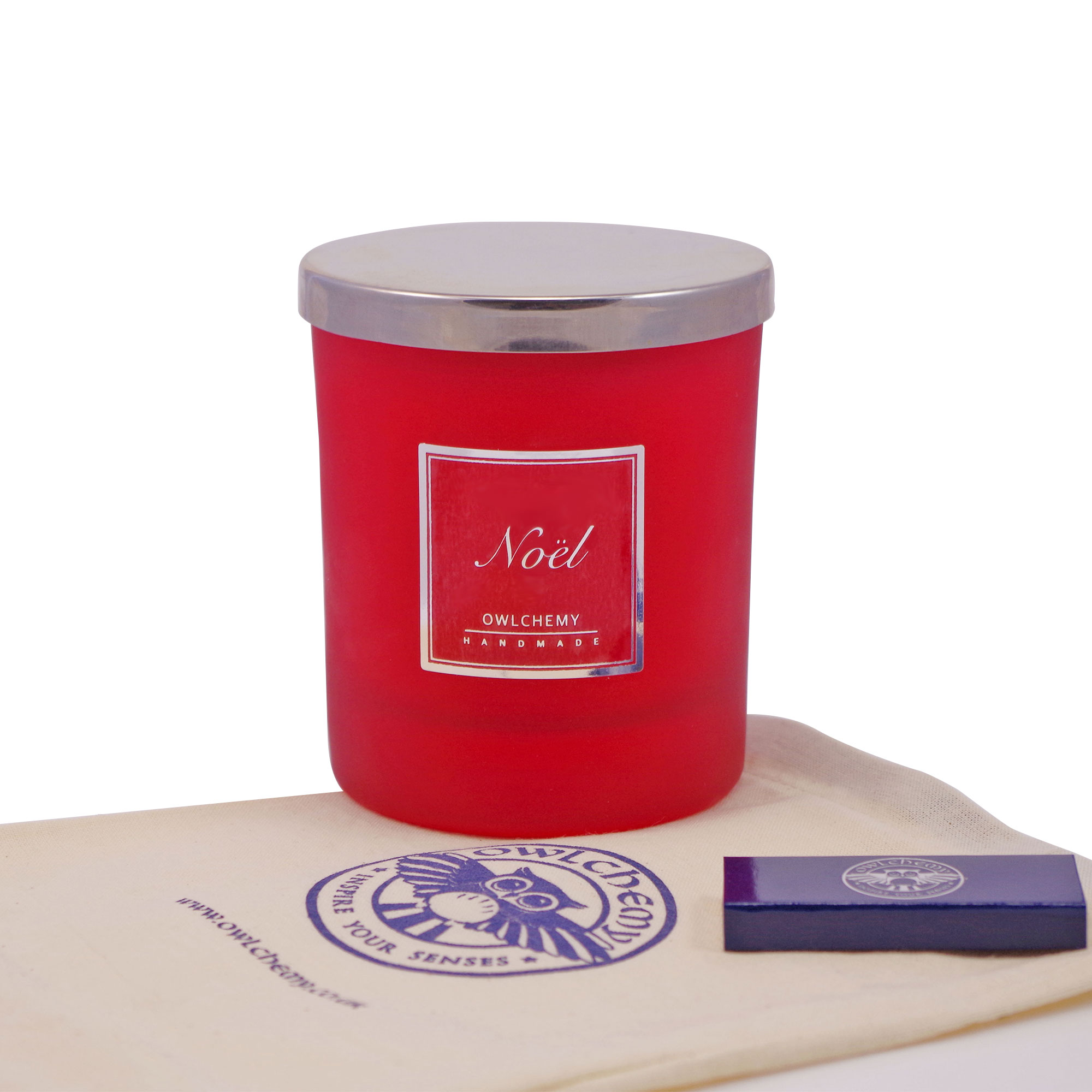Our 250g Noel Luxury Candle placed on top of a bag with accompanying matches.