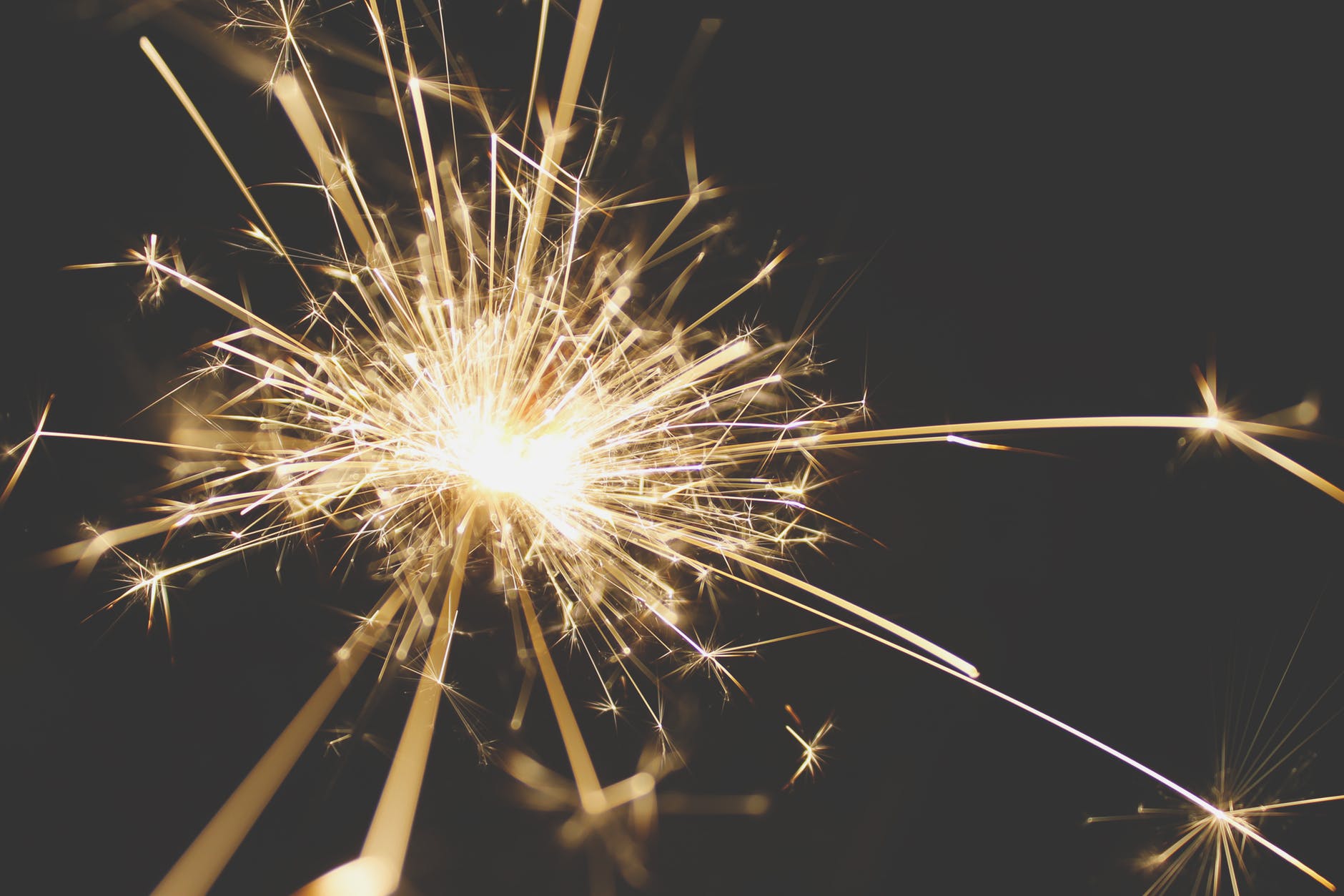 A golden sparkler glowing and streaming in the night air 