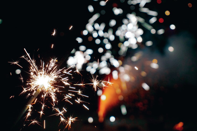 A sparkler going off next to a bonfire to celebrate bonfire night 